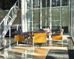 Seating area inside a commercial building with sunlight shining through the windows.